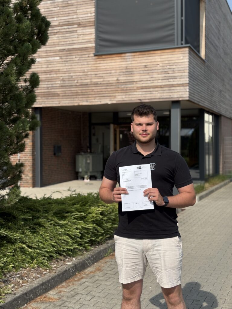 Junger Mann zeigt Bescheinigung der Industrie- und Handelskammer Oldenburg.